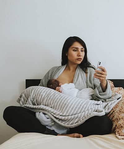 Breastfeeding mother using a smartphone